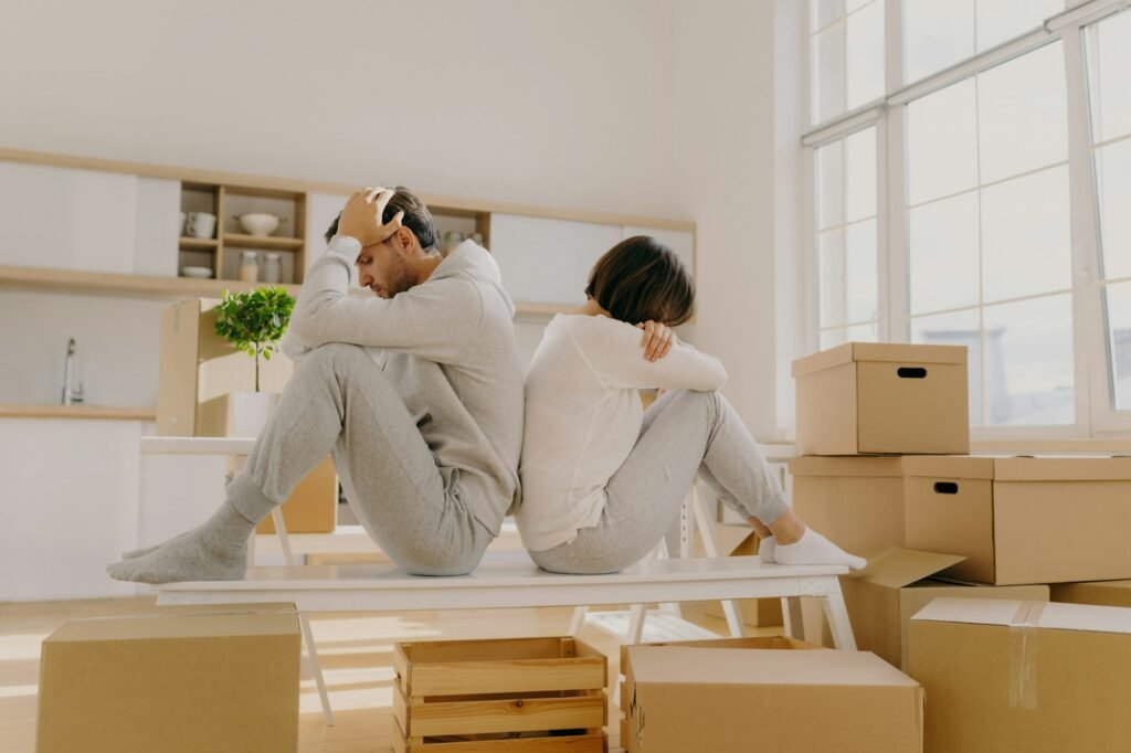 Stressful couple get divorce, leave house, start living separately, sit backs to each other